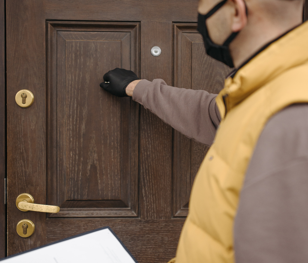 A landlord knocking on a door trying to arrange a property inspection.